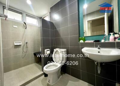 Modern bathroom with shower area, toilet, and sink with mirror