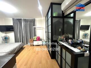 Modern bedroom with wooden flooring and large windows