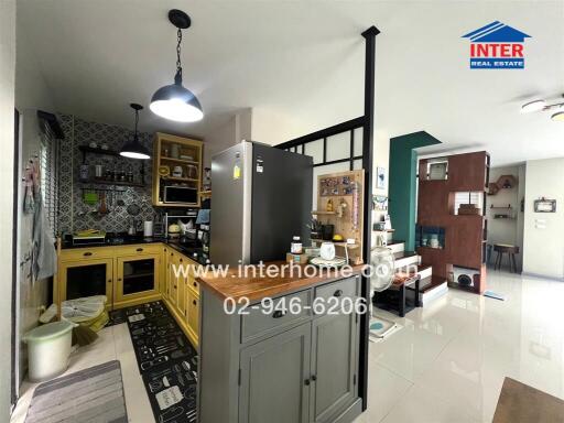 Modern kitchen with yellow cabinets and black refrigerator