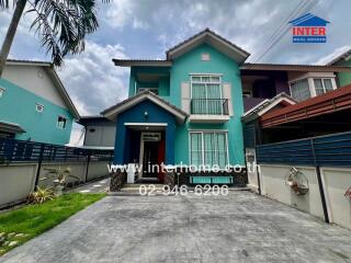 Two-story residential house with driveway and small lawn