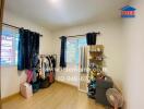 Bedroom with wooden flooring, wardrobe, fan, and personal items