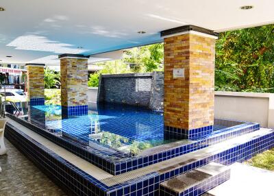 Modern outdoor pool area with blue tile decoration.