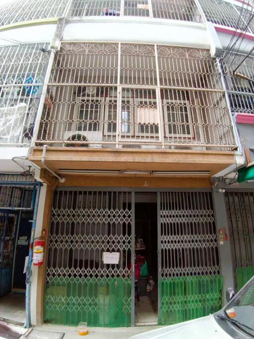 Front view of a multi-storey building with metal grilles