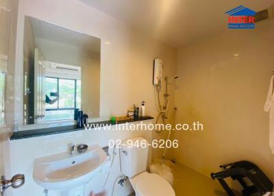 Modern bathroom with sink, toilet, mirror, water heater, and window