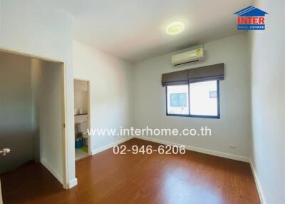 Bedroom with wooden flooring and air conditioner