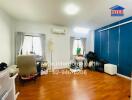 Bright bedroom with wooden floor, large window, and an office chair