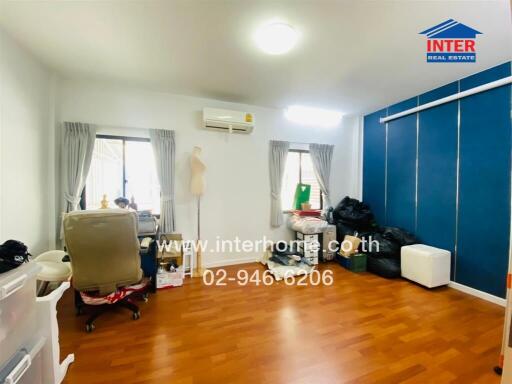 Bright bedroom with wooden floor, large window, and an office chair