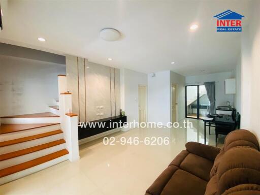 Spacious living room with staircase and natural lighting