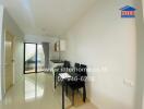 Small dining area with a table and chairs, beside a kitchen