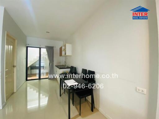 Small dining area with a table and chairs, beside a kitchen