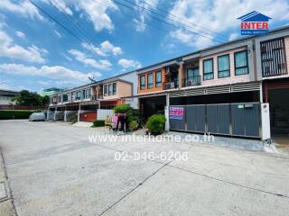 Modern townhouses with outdoor parking and clear blue sky