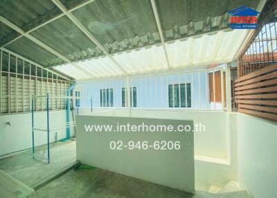 Covered outdoor space with railings and contact information