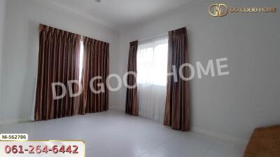 A bedroom with white tiles and brown curtains