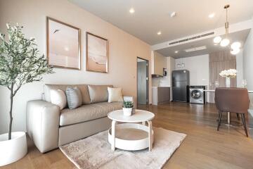 Modern living room with sofa, coffee table, dining area, and kitchen