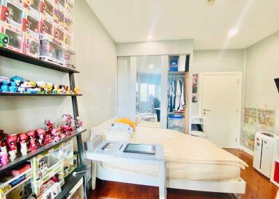 Bedroom with collectibles and plushies on shelves, bed, and wardrobe