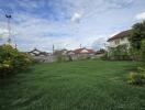 Spacious backyard with lush green lawn and flowering shrubs