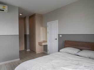 Modern bedroom with bed, closets, air conditioning, and wooden floor