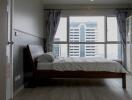 Modern bedroom with large window and city view