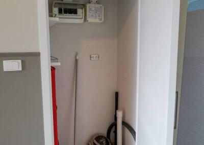 Photo of a utility closet with cleaning supplies and electrical panels