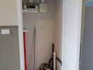 Photo of a utility closet with cleaning supplies and electrical panels