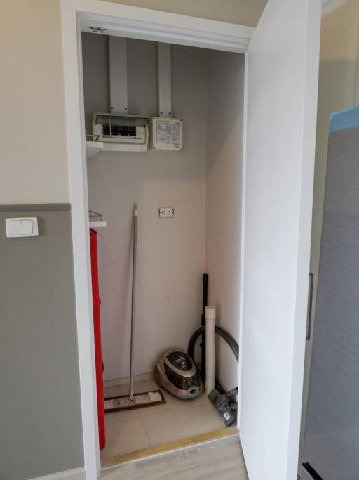 Photo of a utility closet with cleaning supplies and electrical panels