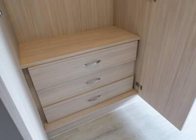 Wooden wardrobe with open door showing three drawers