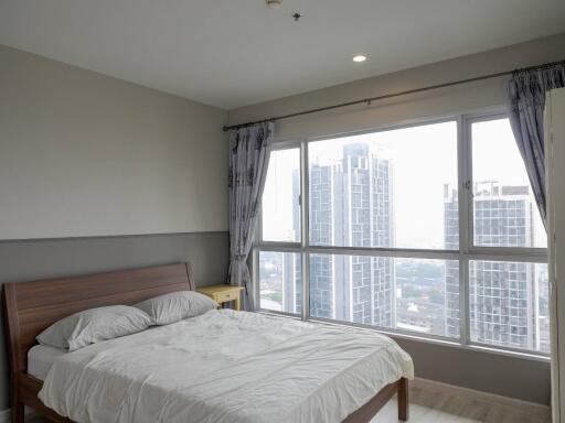 Modern bedroom with large windows and city view