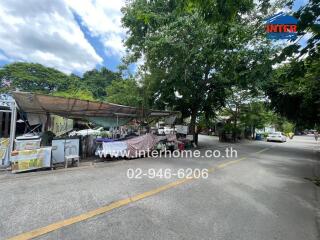 Street view with vendor stalls and green trees