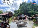 Outdoor seating area with trees and a cafe in the background