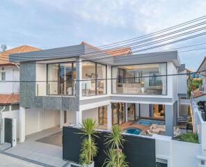 Modern two-story house with large windows and a swimming pool