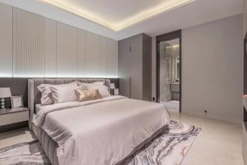 Modern bedroom with a large bed, nightstands, and en-suite bathroom