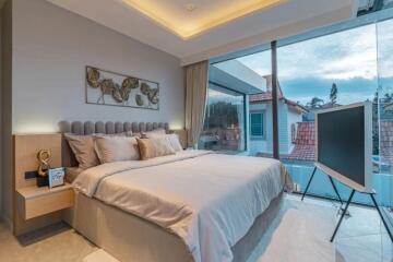 Modern bedroom with a large bed and floor-to-ceiling windows