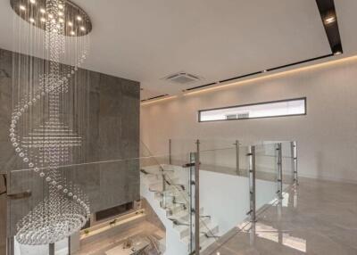 Modern interior with chandelier and glass staircase