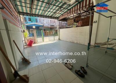 Covered outdoor space with tiled floor and open gate