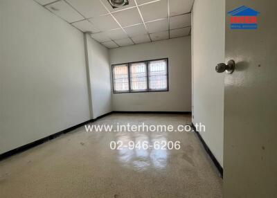 Empty bedroom with tiled floor and barred windows