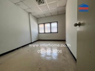 Empty bedroom with tiled floor and barred windows