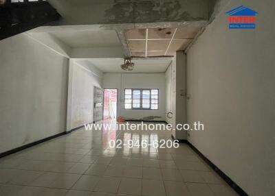 Spacious living area with tiled flooring and natural light