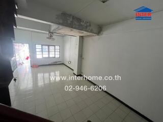 Empty living room with white walls, tiled floor, and ceiling fan