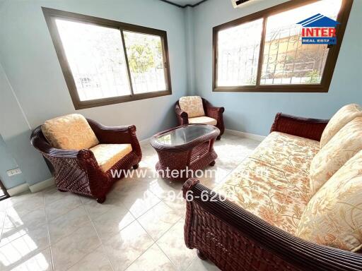 Living room with rattan furniture and large windows