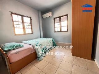 Bedroom with bed, wardrobe and air conditioner