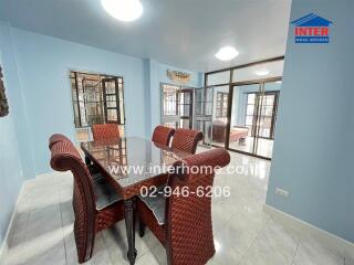 Dining room with a glass-top table and wicker chairs