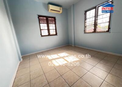 A well-lit bedroom with tiled flooring and air conditioning.