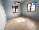 A well-lit bedroom with tiled flooring and air conditioning.