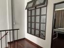 Spacious hallway with wooden flooring and large window screens