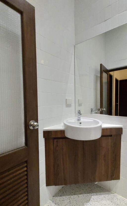 Modern bathroom with wooden cabinet and large mirror