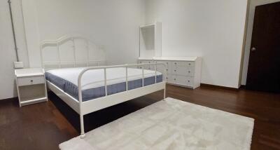 Spacious bedroom with bed, dresser, and nightstand