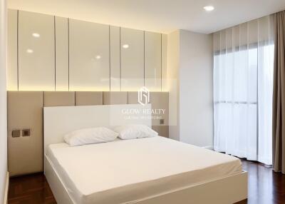 Modern bedroom with a large bed, stylish lighting, and ample storage