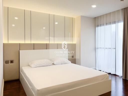 Modern bedroom with a large bed, stylish lighting, and ample storage