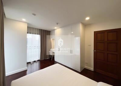 Spacious bedroom with large window, built-in wardrobe, and adjacent study area