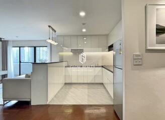 Modern kitchen with white cabinets and city view